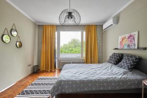 a bedroom with a bed and a large window at LAZUR ~ 2BD Flat next to the Sea Garden in Burgas City