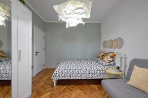 a bedroom with a bed and a couch and a chandelier at LAZUR ~ 2BD Flat next to the Sea Garden in Burgas City