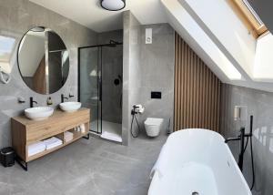 a bathroom with two sinks and a large mirror at Hotel Horal in Rožnov pod Radhoštěm