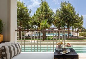 ein Wohnzimmer mit einem weißen Sofa und Poolblick in der Unterkunft Anantara Vilamoura Family Friendly in Vilamoura