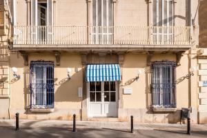 - un bâtiment avec une porte blanche et un balcon dans l'établissement Hotel Medium Romantic, à Sitges