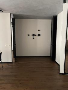 ein leeres Zimmer mit einer weißen Wand mit einem Kronleuchter in der Unterkunft Carlo Apartments in Birštonas