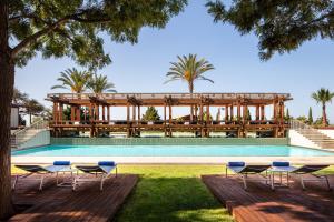 einen Pool mit Stühlen und einem Pavillon in der Unterkunft Anantara Vilamoura Family Friendly in Vilamoura