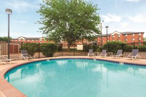 una piscina con sedie, un albero e edifici di Hampton Inn Des Moines-Airport a Des Moines