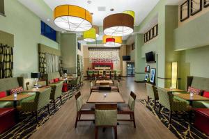 a restaurant with wooden tables and chairs and lights at Hampton Inn & Suites Williamsport - Faxon Exit in Williamsport