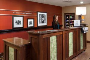 a woman standing at a counter in a waiting room at Hampton Inn & Suites Williamsport - Faxon Exit in Williamsport