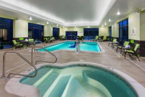 a pool in a hotel room with tables and chairs at Hampton Inn & Suites Williamsport - Faxon Exit in Williamsport