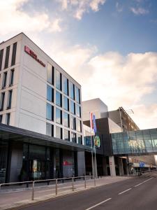 un bâtiment situé sur le côté d'une rue dans l'établissement Hilton Garden Inn Krakow Airport, à Cracovie