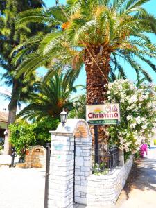 una palmera y un cartel para un hotel en Villa Christina, en Tolo