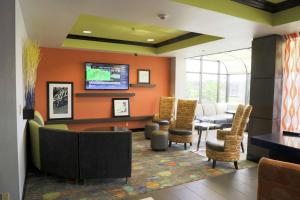 een wachtkamer met een bank en een tafel en stoelen bij Hampton Inn Muskogee in Muskogee