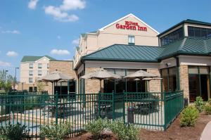 un restaurant avec des parasols en face d'un bâtiment dans l'établissement Hilton Garden Inn Bowling Green, à Bowling Green