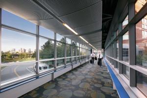 persone che camminano lungo un corridoio in un edificio con finestre di Hilton Boston Logan Airport a Boston