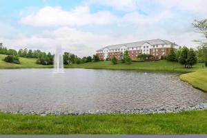 un bâtiment avec une fontaine au milieu d'un lac dans l'établissement Hilton Garden Inn Charlottesville, à Charlottesville