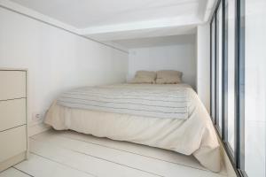 um quarto branco com uma cama e uma janela em Studio Part Dieu em Lyon