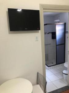 ein Badezimmer mit einem Tisch und einem TV an der Wand in der Unterkunft Hotel Natal in Santos