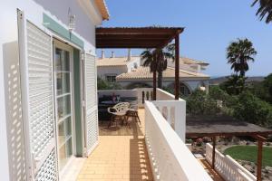 einen Balkon mit Blick auf ein Haus in der Unterkunft Stunning Villa with Pool & View near beach in Budens