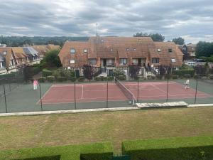 twee mensen die tennissen op een tennisbaan bij Picsine, Tennis résidence sévigné 300m mer in Deauville