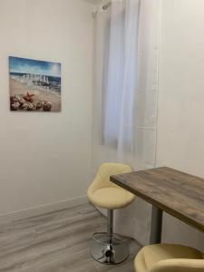 uma mesa e cadeiras num quarto com uma pintura em CagliariParadiseApartment it Marina em Cagliari