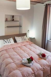 een slaapkamer met een groot roze bed met handdoeken en rozen bij Casa Vacanze Le Cascate in Le Marmore