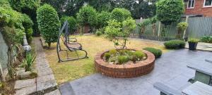 un giardino con panchina in mezzo a un cortile di Spacious, 5 bed house for 9 in Chester a Chester