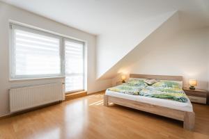 Una cama o camas en una habitación de Apartmány Frýda