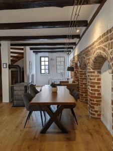 comedor con mesa de madera y pared de ladrillo en BacksteinFlair - LüneMitte, en Lüneburg