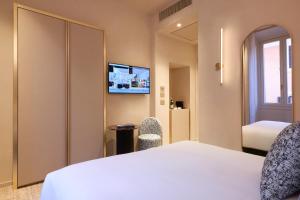 ein Hotelzimmer mit einem Bett und einem TV in der Unterkunft Borghese Contemporary Hotel in Rom