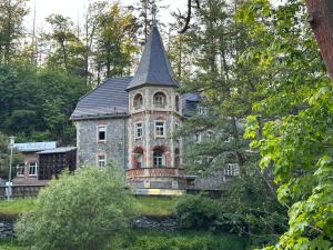 ein altes Steinhaus mit einem Turm auf einem Hügel in der Unterkunft Hotel Bodeblick in Thale