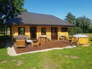 eine Holzterrasse mit Stühlen und ein Haus in der Unterkunft Upeslīči atpūtai in Jelgava