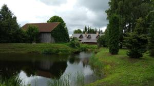 ein Haus und ein Fluss mit einer Brücke im Hintergrund in der Unterkunft Upeslīči atpūtai in Jelgava