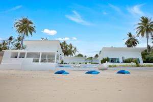 a house on the beach with blue bags on the sand at La Perle Resort Koh Samui in Mae Nam