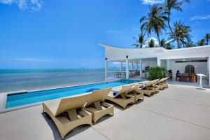 a villa with a swimming pool next to the ocean at La Perle Resort Koh Samui in Mae Nam