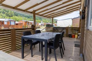 d'une terrasse avec une table et des chaises. dans l'établissement Grand Mobil Home 6 personnes climatisé avec 3 chambres et 2 salles de bains à Munster en Alsace, à Munster