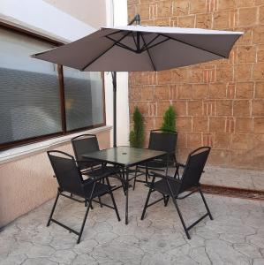 - une table et des chaises avec un parasol sur la terrasse dans l'établissement Hotel Tlaxcala, à Tlaxcala de Xicohténcatl