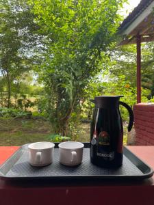 Una bandeja con una cafetera y dos tazas. en Wild Valley Club, en Masinagudi