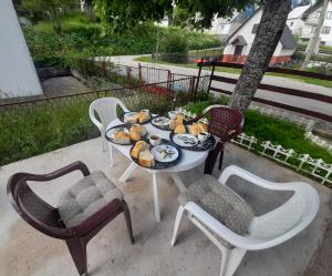 une table avec une assiette de nourriture et des chaises dans l'établissement Guesthouse Durmitor Magic, à Žabljak