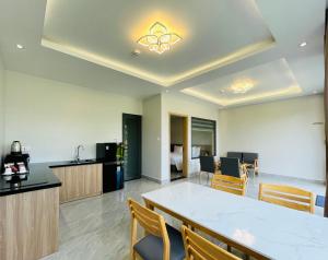 a room with a table and chairs and a kitchen at Sunflower Hotel & Resort in Bao Loc