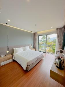 a bedroom with a large bed and a large window at Sunflower Hotel & Resort in Bao Loc