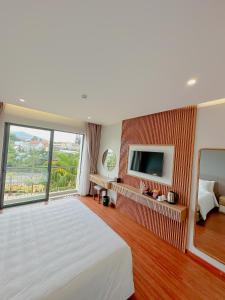 a bedroom with a large bed and a tv at Sunflower Hotel & Resort in Bao Loc