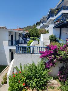 Une rangée de maisons blanches avec des fleurs violettes et roses dans l'établissement Brilliance Apartments, à Ouranoupoli