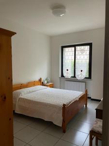 um quarto com uma cama grande e uma janela em Casa Maria-Appartamento in Villa em Ispra