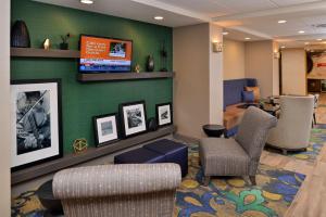 sala de estar con sillas y TV de pantalla plana en Hampton Inn Broussard-Lafayette, en Broussard