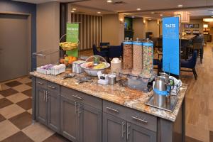 un mostrador de desayuno en el vestíbulo del hotel con comida. en Hampton Inn Broussard-Lafayette, en Broussard