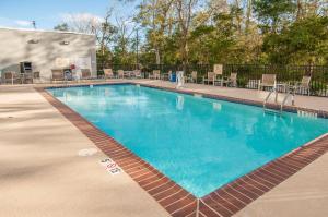 een zwembad in een resort met tafels en stoelen bij Hampton Inn Opelousas in Opelousas