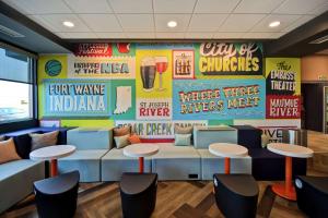 ein Wartezimmer in einem Fast-Food-Restaurant mit Tischen und Stühlen in der Unterkunft Tru By Hilton Fort Wayne in Fort Wayne