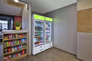 a store aisle with a refrigerator with food and drinks at Home2 Suites By Hilton Holland in Holland