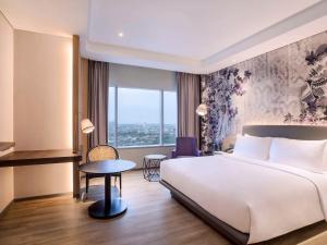 A bed or beds in a room at Mercure Jakarta Gatot Subroto