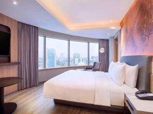 A bed or beds in a room at Mercure Jakarta Gatot Subroto