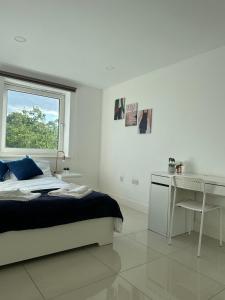 1 dormitorio con cama, escritorio y ventana en 3 Bed Cozy Apartment - next to Leeds City Centre & University, en Headingley