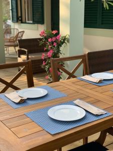 een houten tafel met witte borden en servetten erop bij Nisaki Mathraki B&B in Corfu-stad